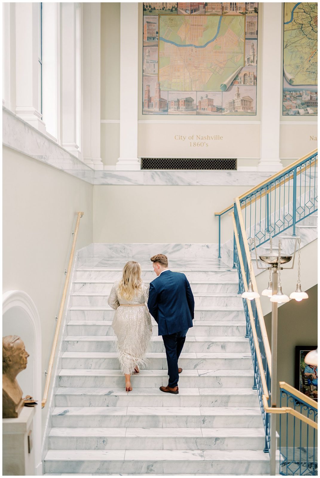 couple walk up marble staircase inside Nashville public library