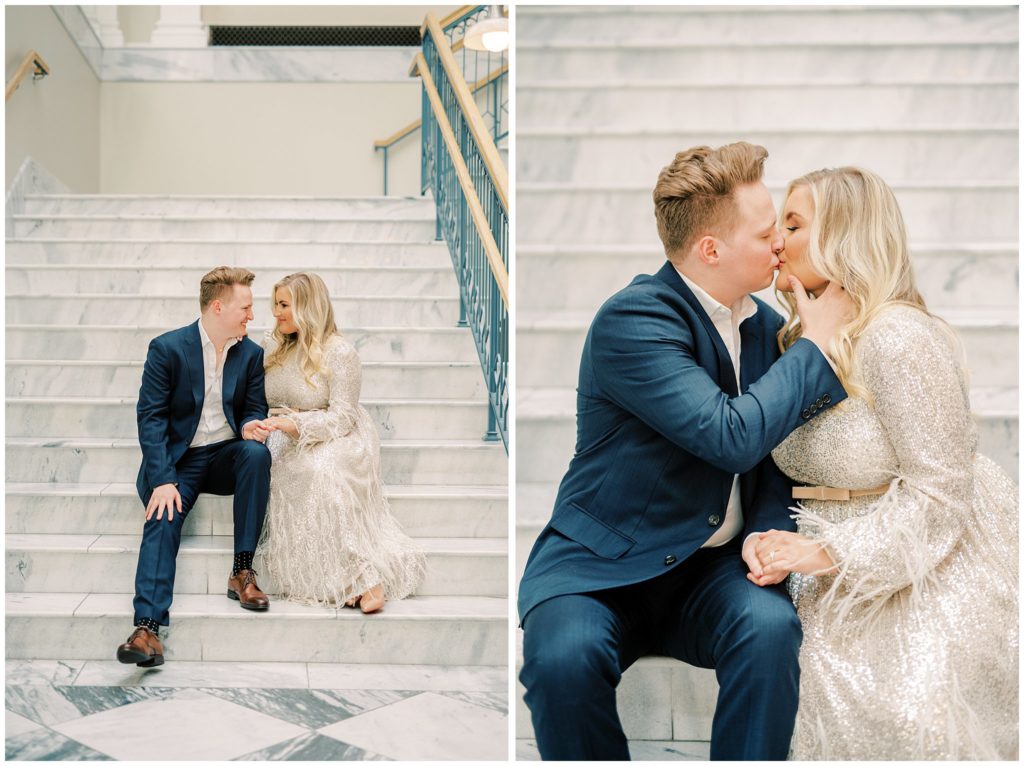 engaged couple kiss as they sit on marble staircase