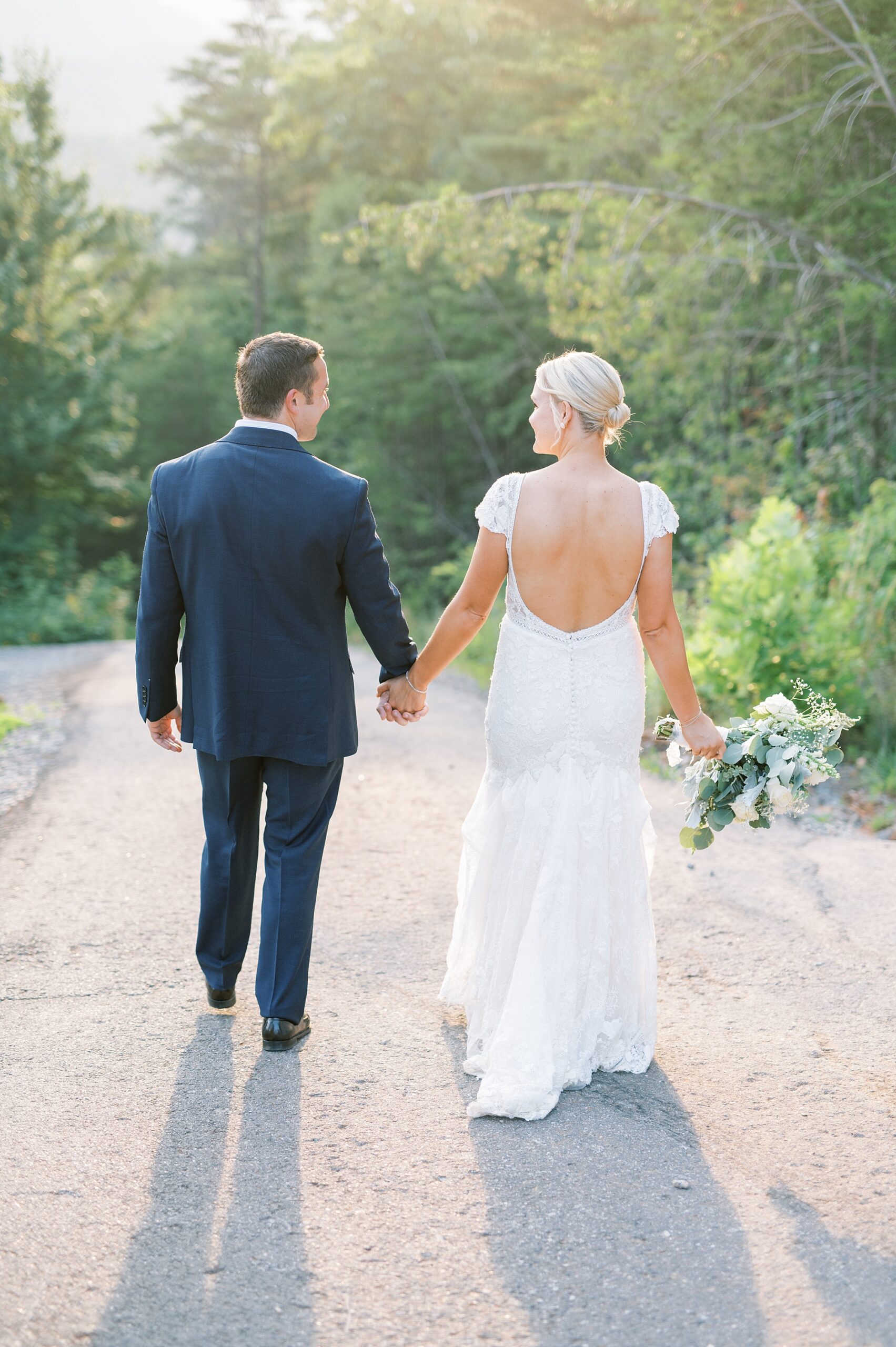 bride and groom walk together holding hands