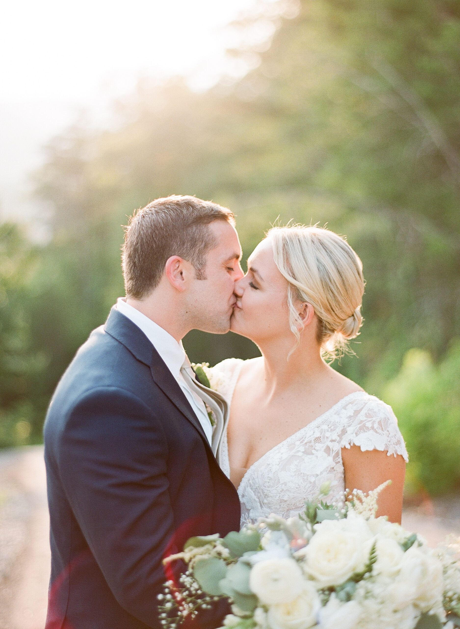bride and groom kiss during wedding portraits