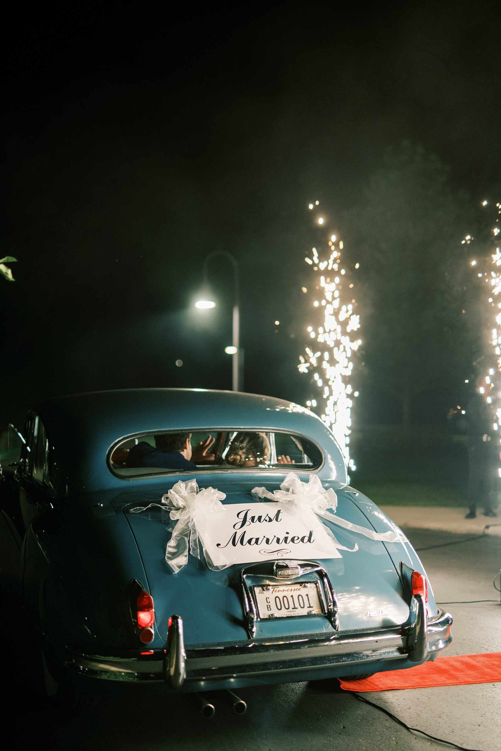 newlyweds in car with Just Married sign on back