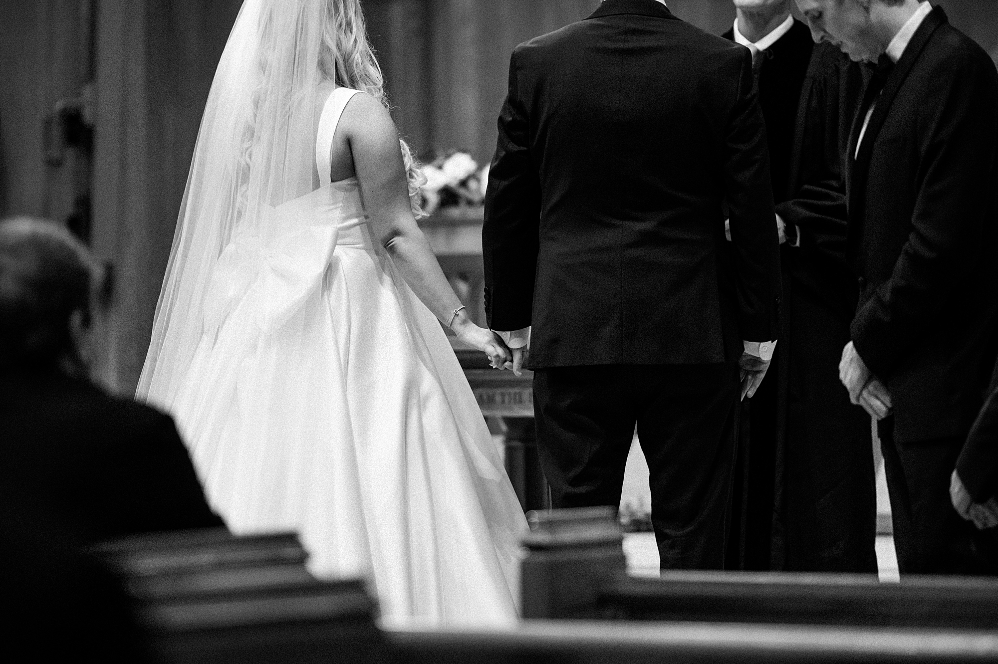 bride and groom hold hands during wedding