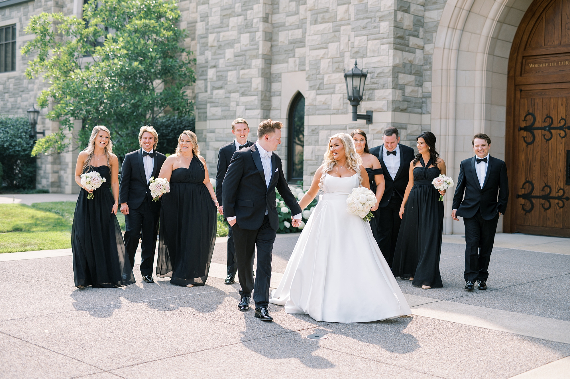 bride and groom with their wedding party dressed in black