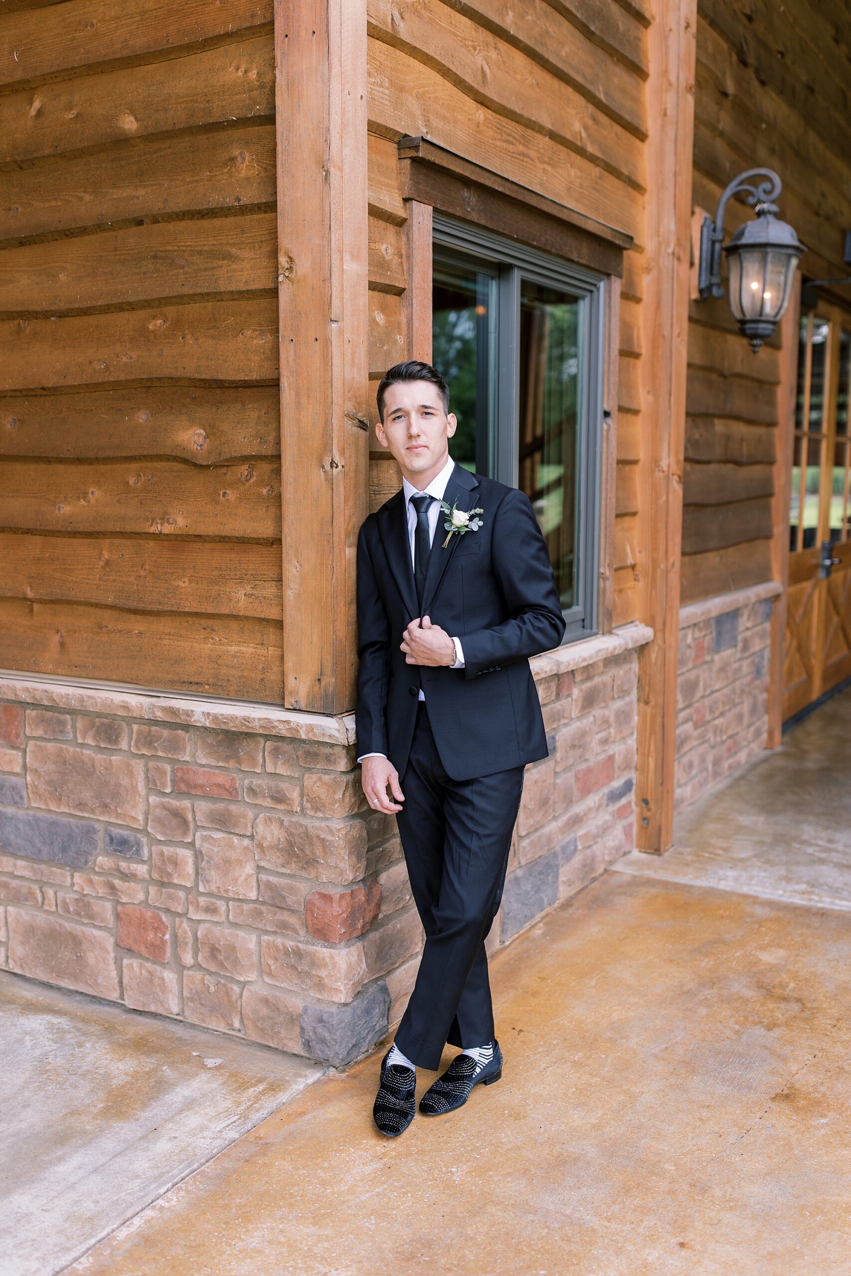 groom standing outside of The Barn at Sycamore Farms
