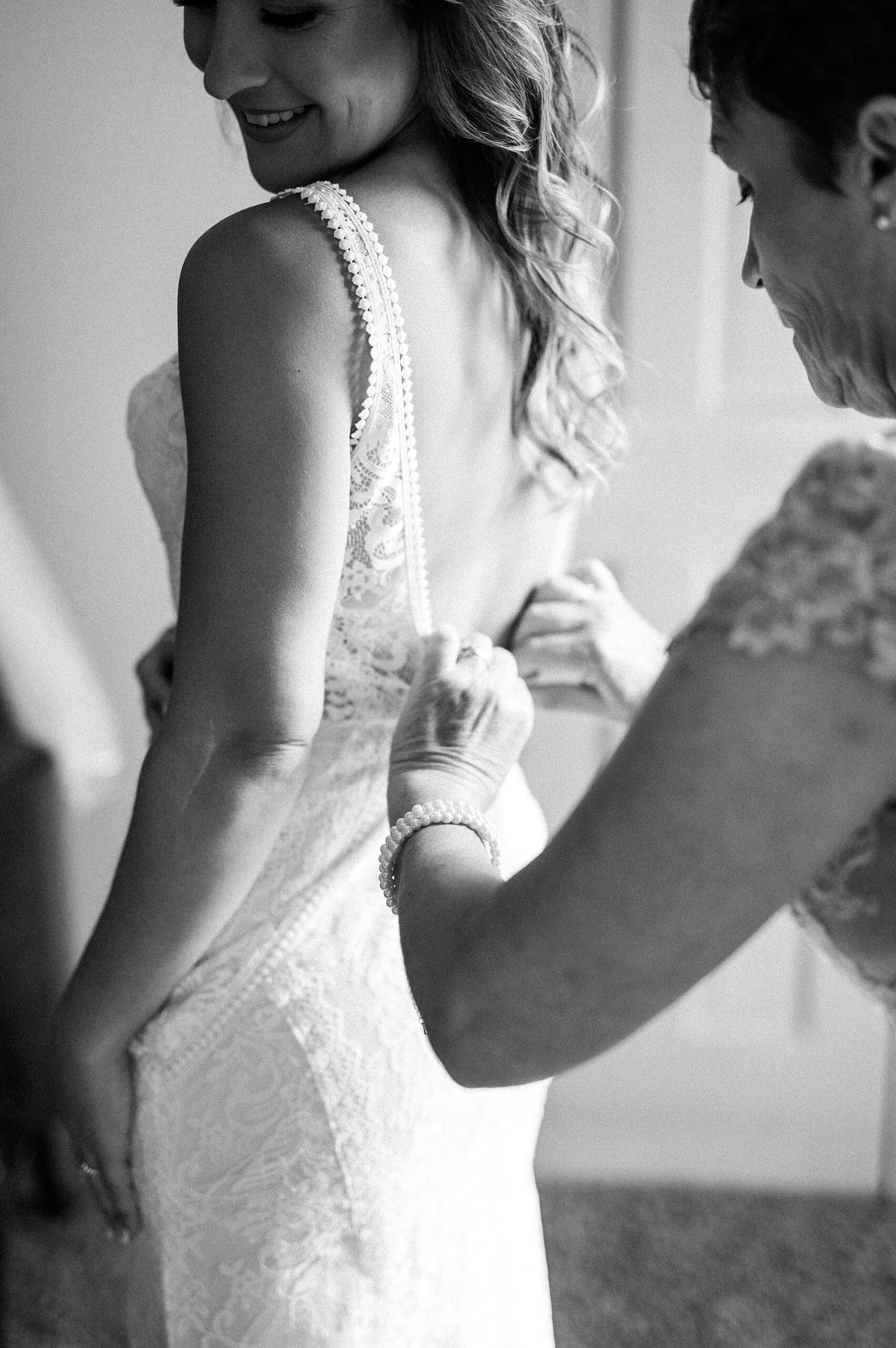 mother helps her daughter into wedding dress