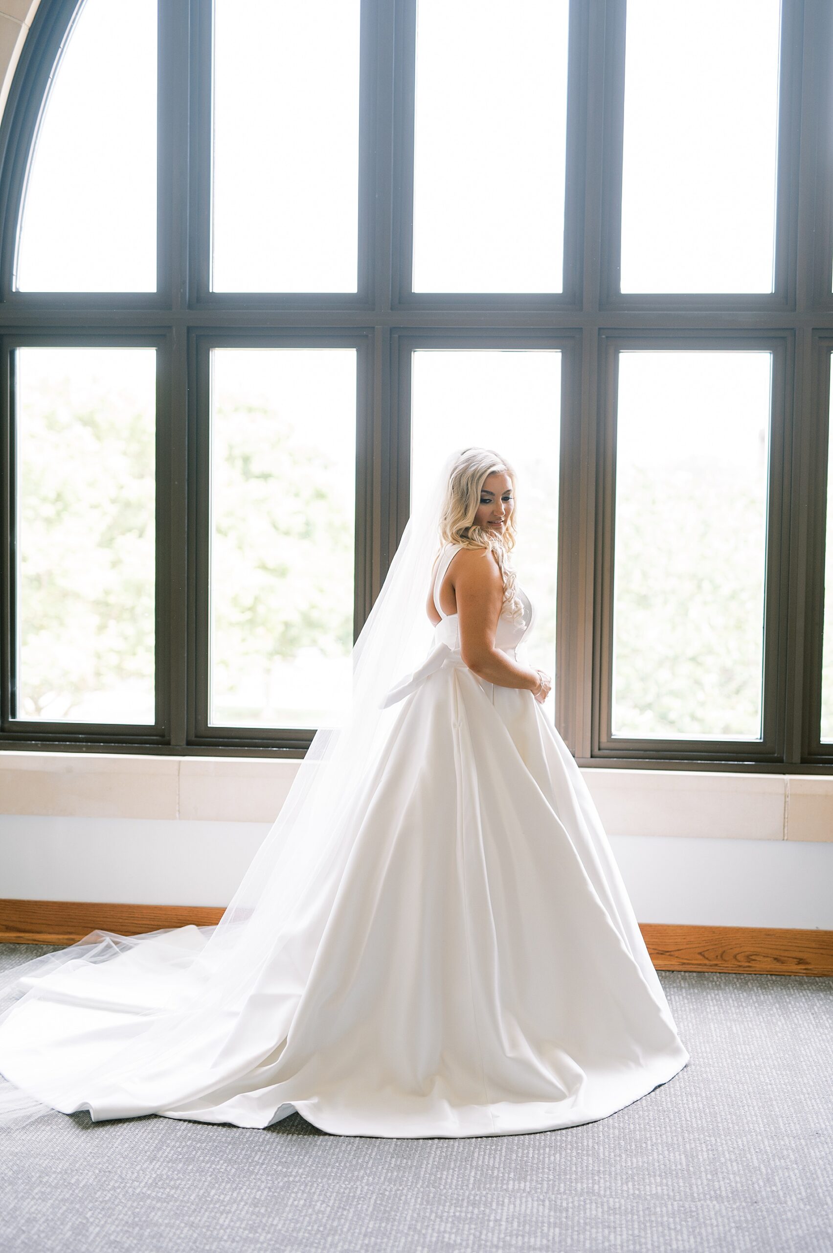 bridal portraits in front of large window 