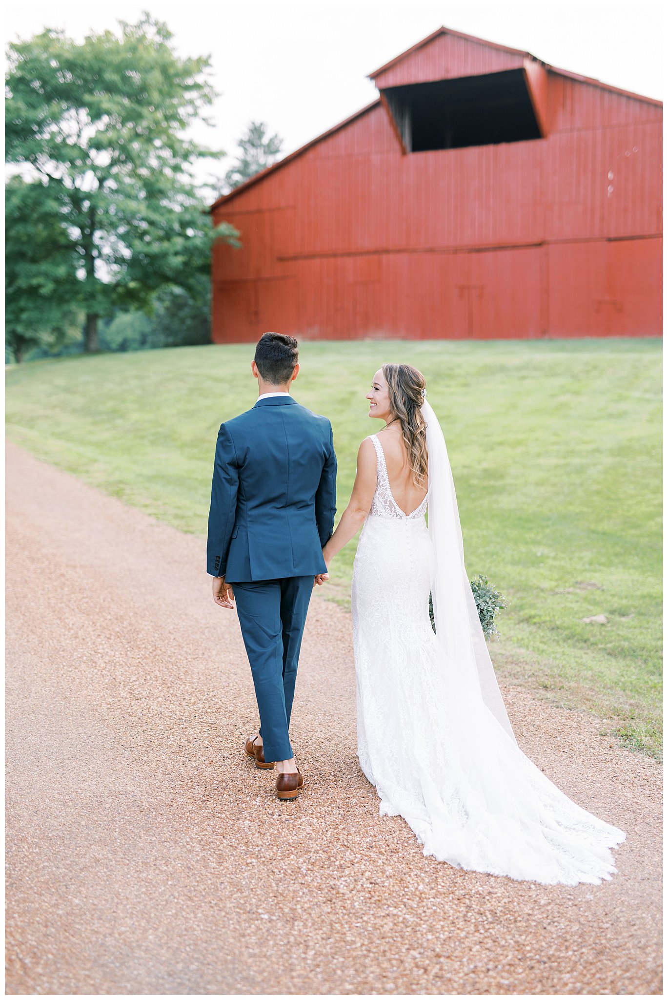 newlyweds walk together along gravel path
