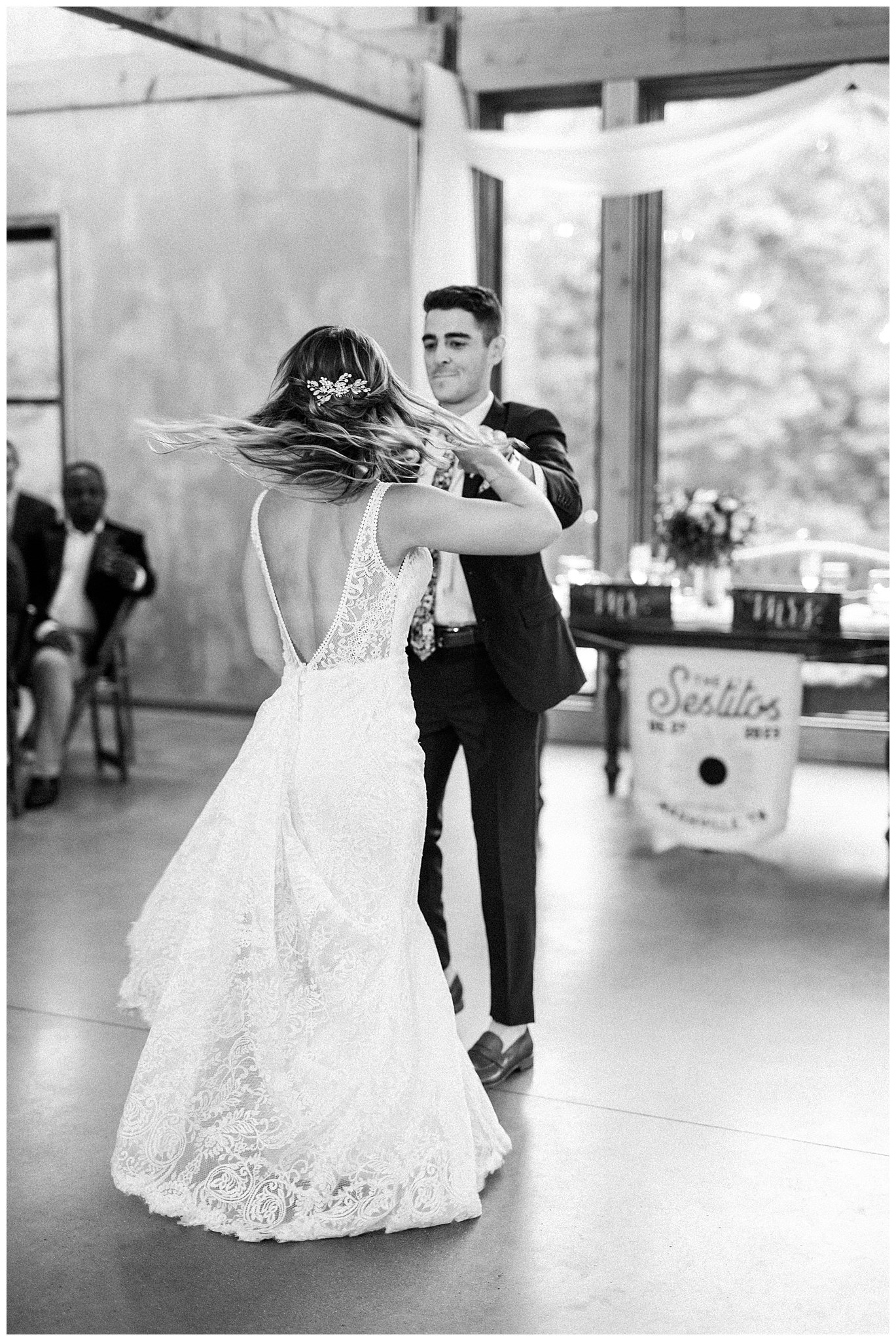 groom spins his bride around on the dance floor