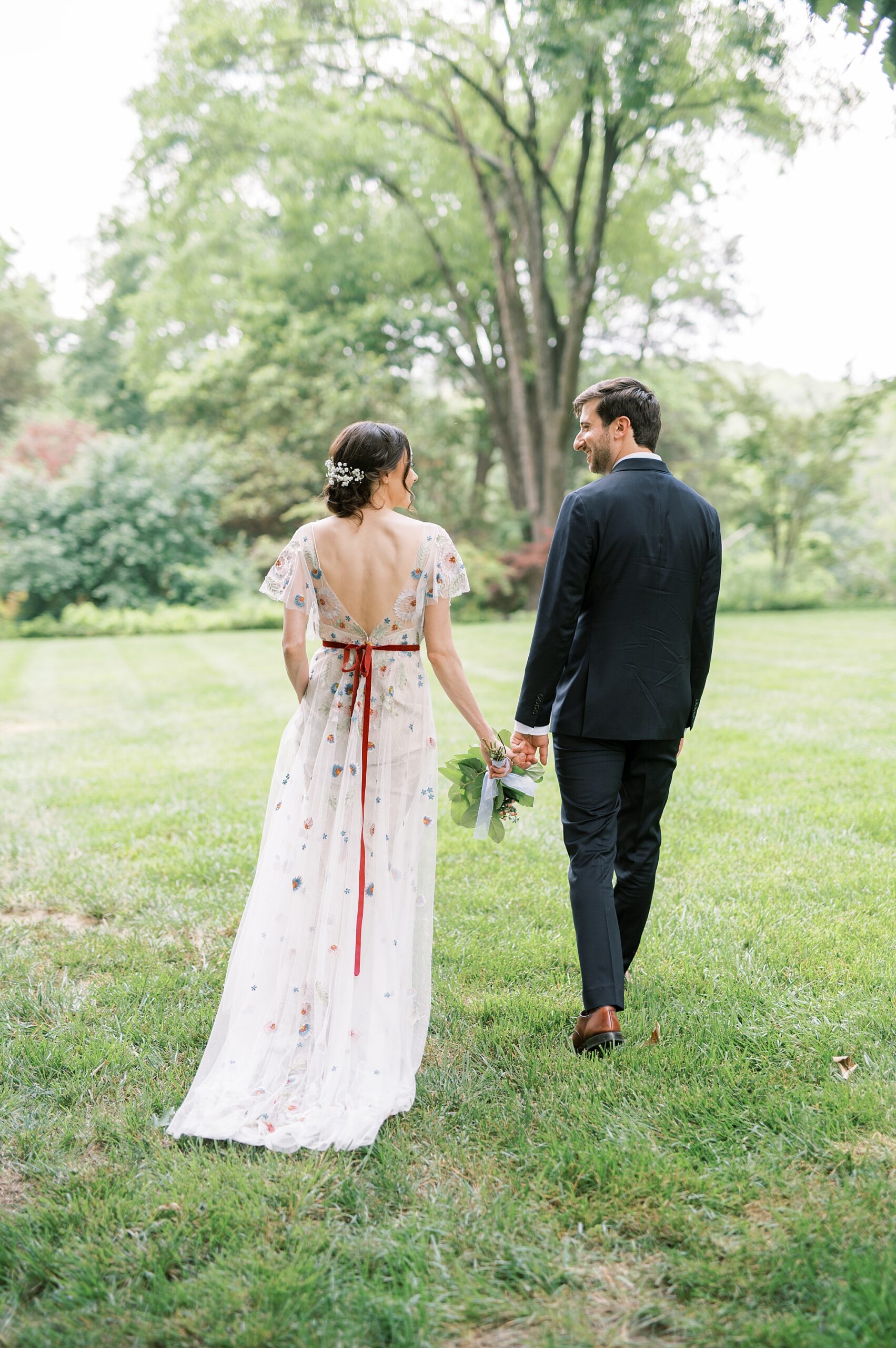 bride and groom walk together holding hands