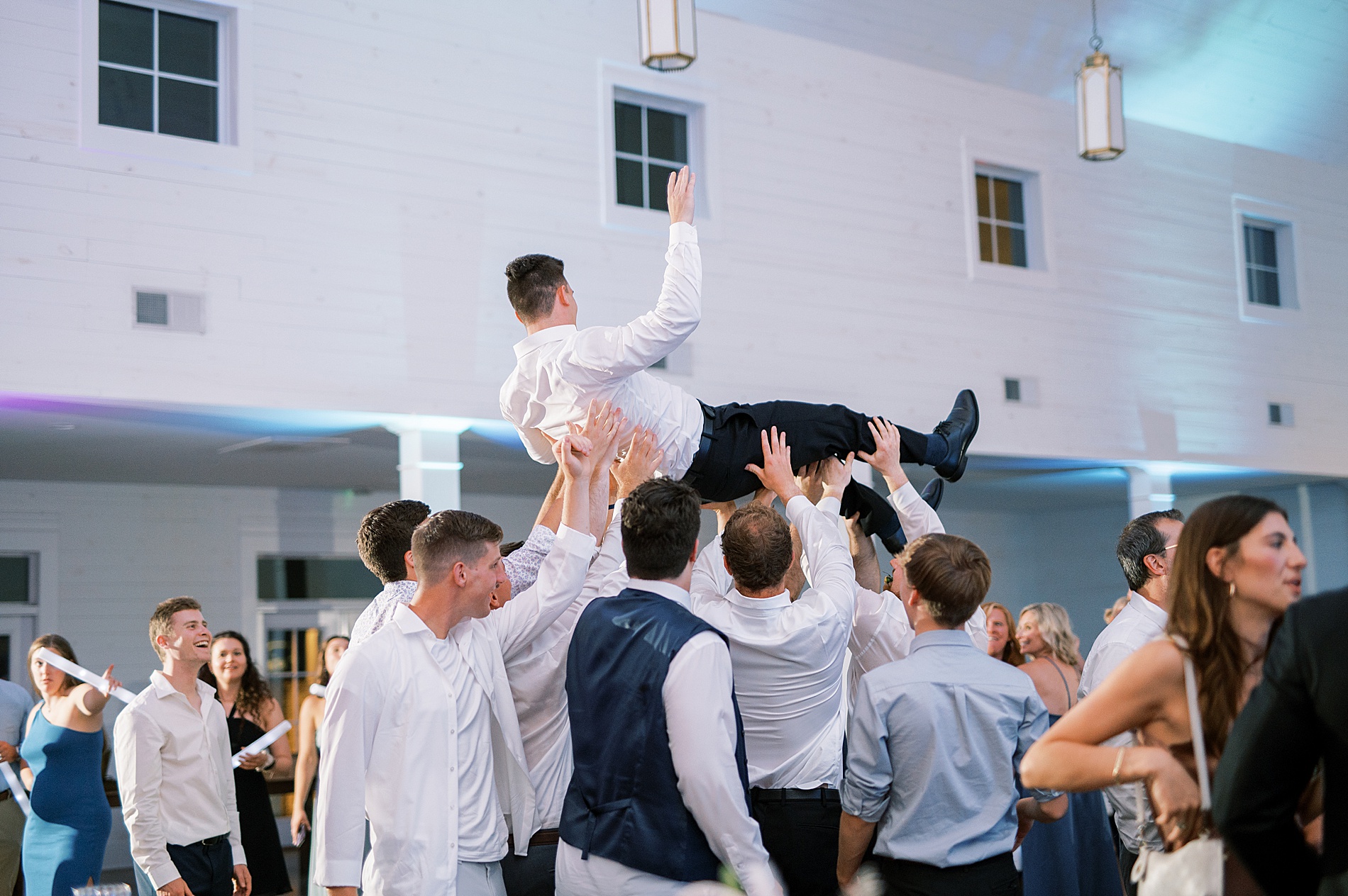 groom is lifted up by guests at Southern Harvest Hollow Wedding