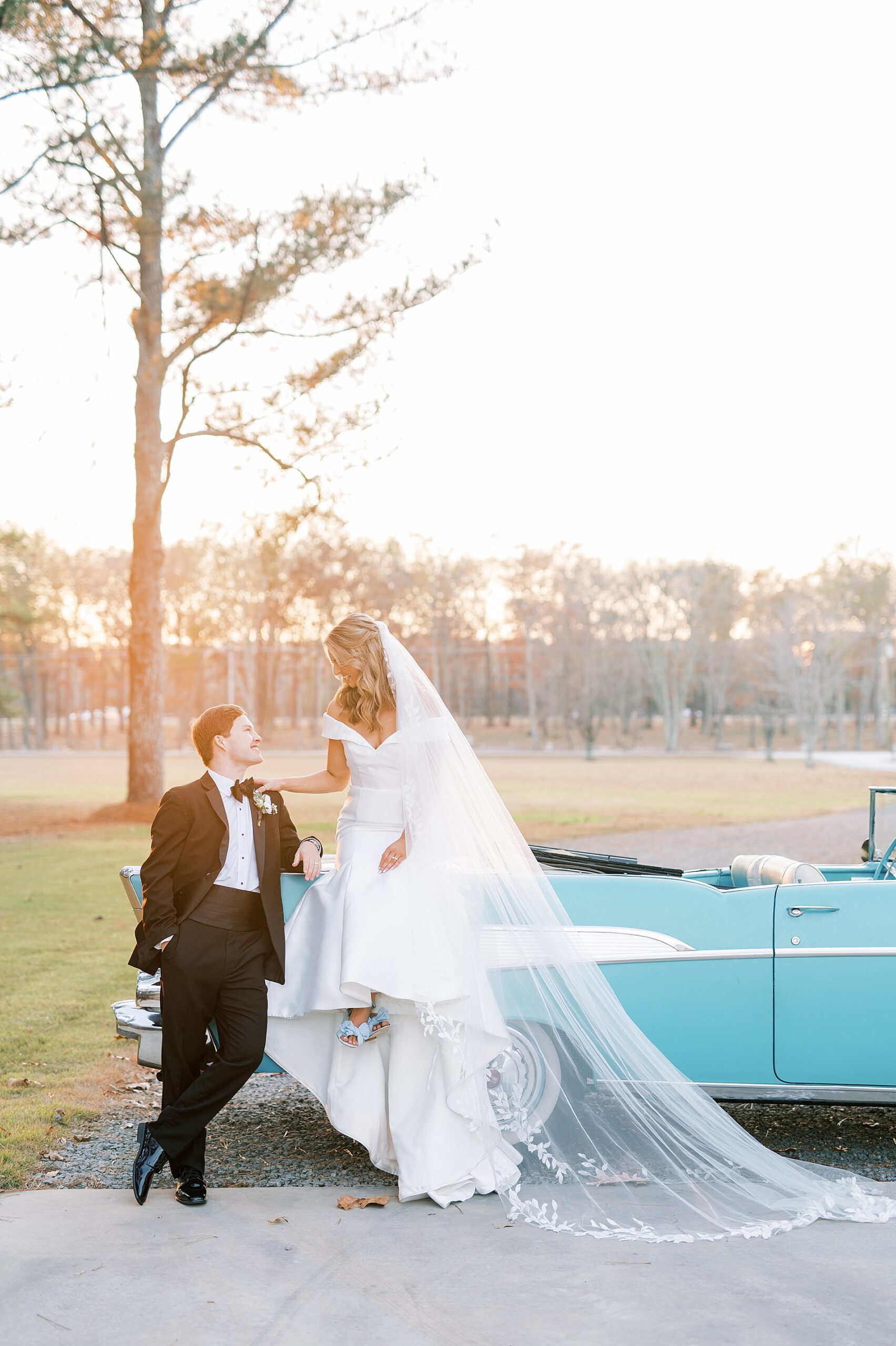 newlyweds sit on classic car