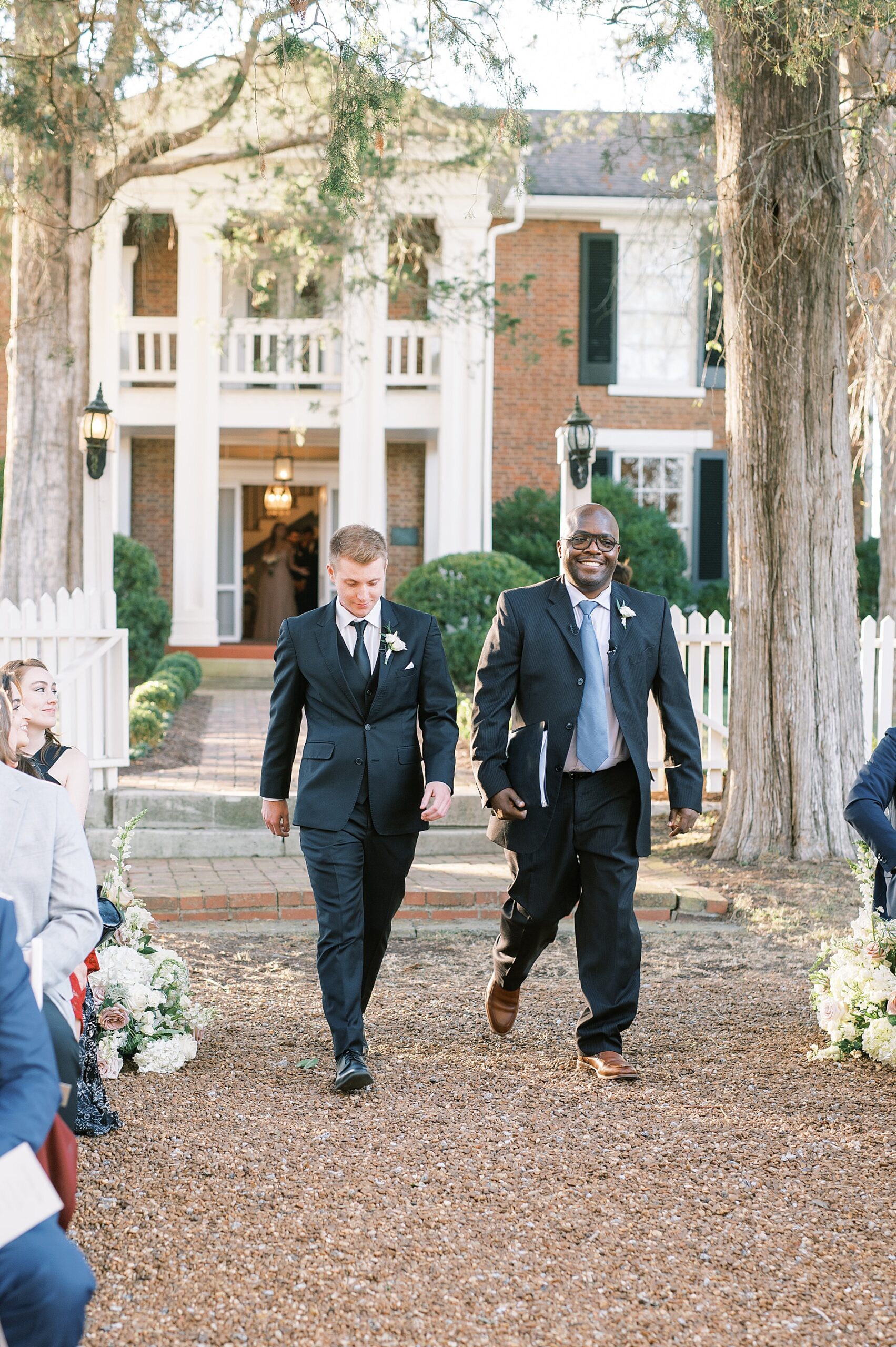 groom and pastor walking down aisle at ceremony
