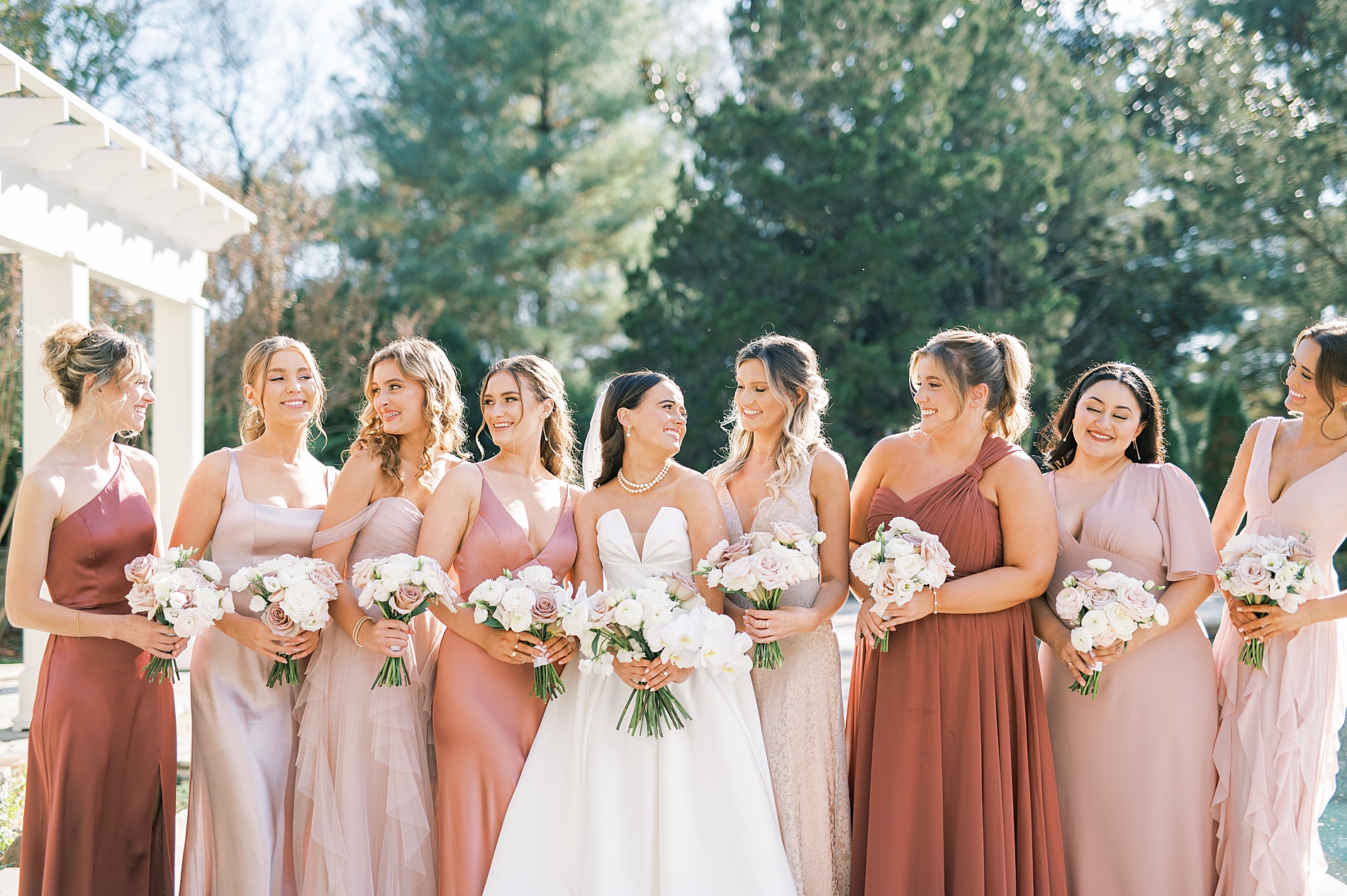 bride and bridesmaids in different blush colored dresses
