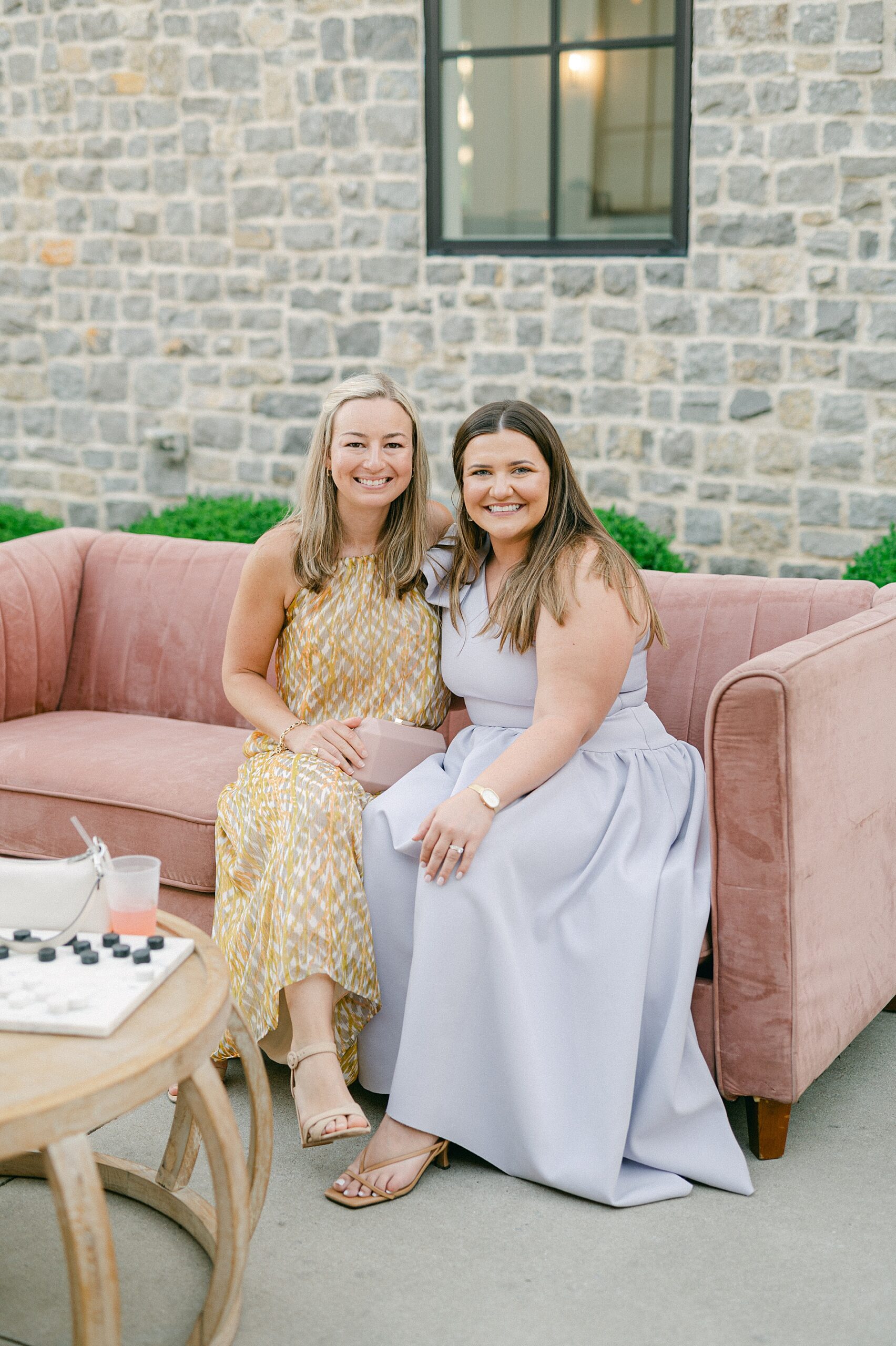 guests sitting on blush couch outside