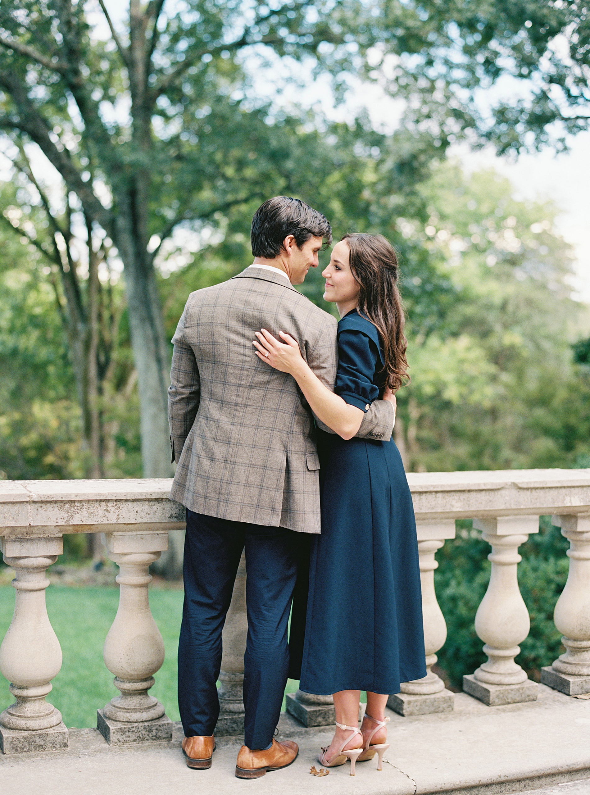couple look at each other while looking out over a bridge