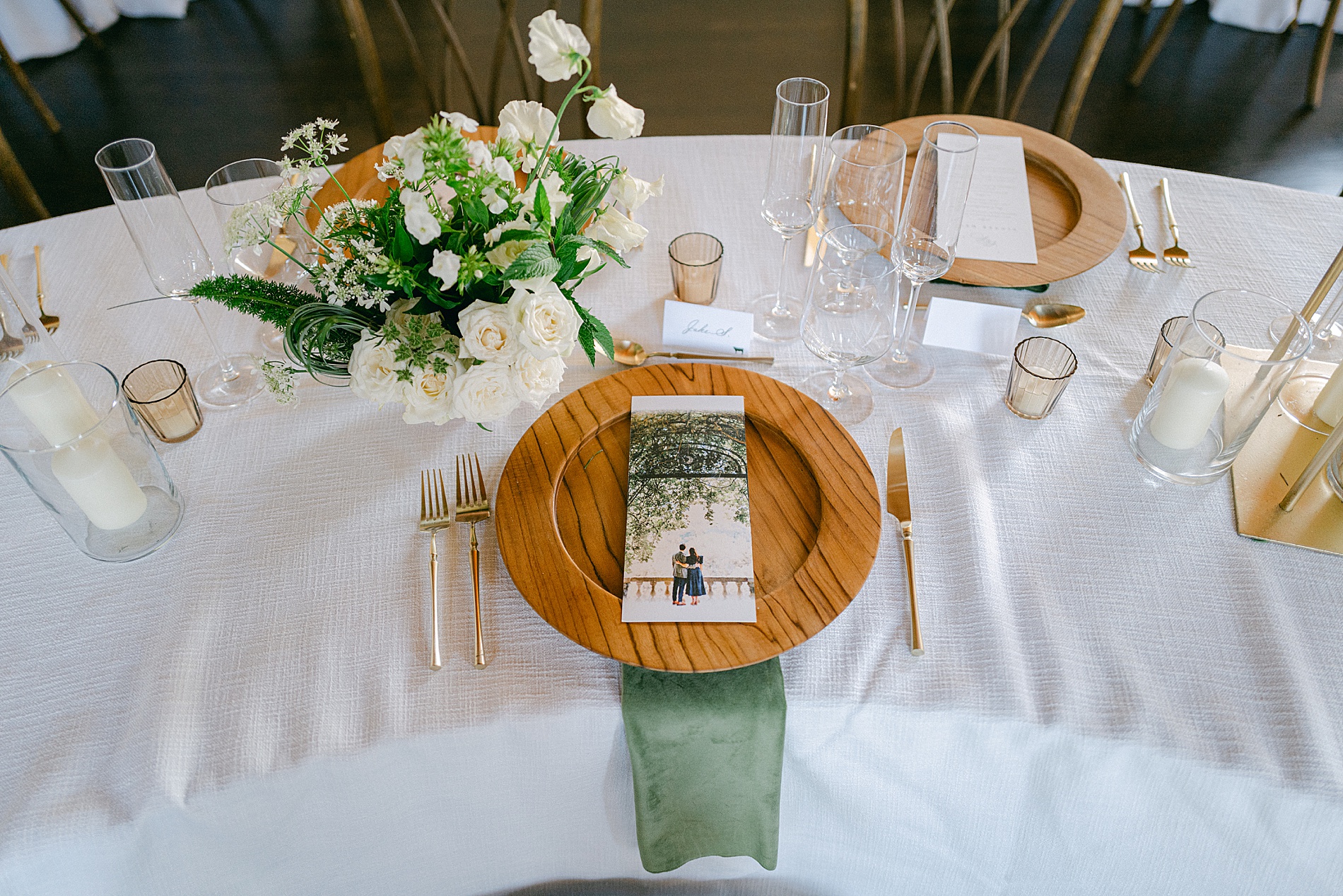 white linens with wood plate and green napkin create a natural place setting 