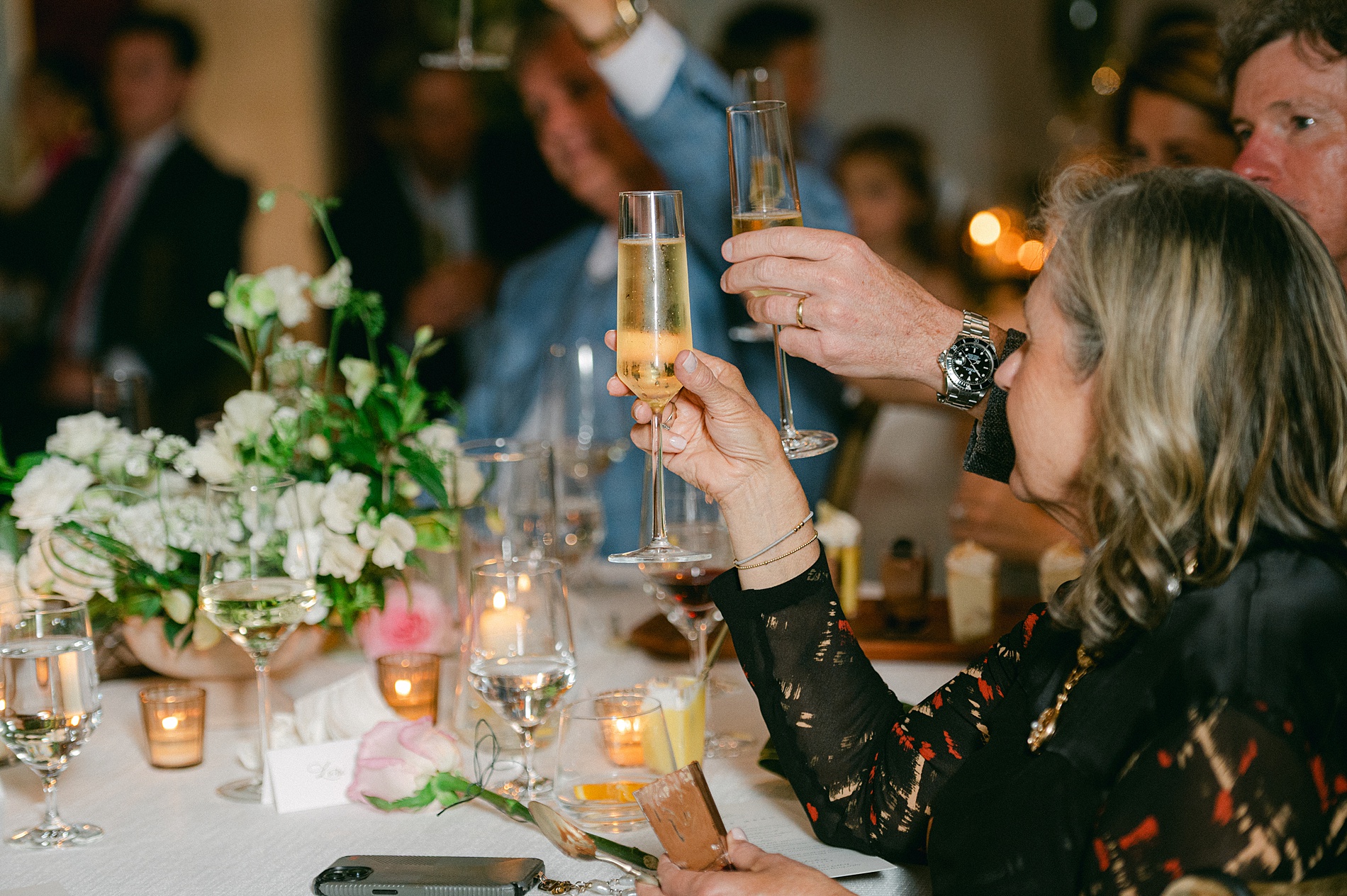 guests raise their glasses to toast couple
