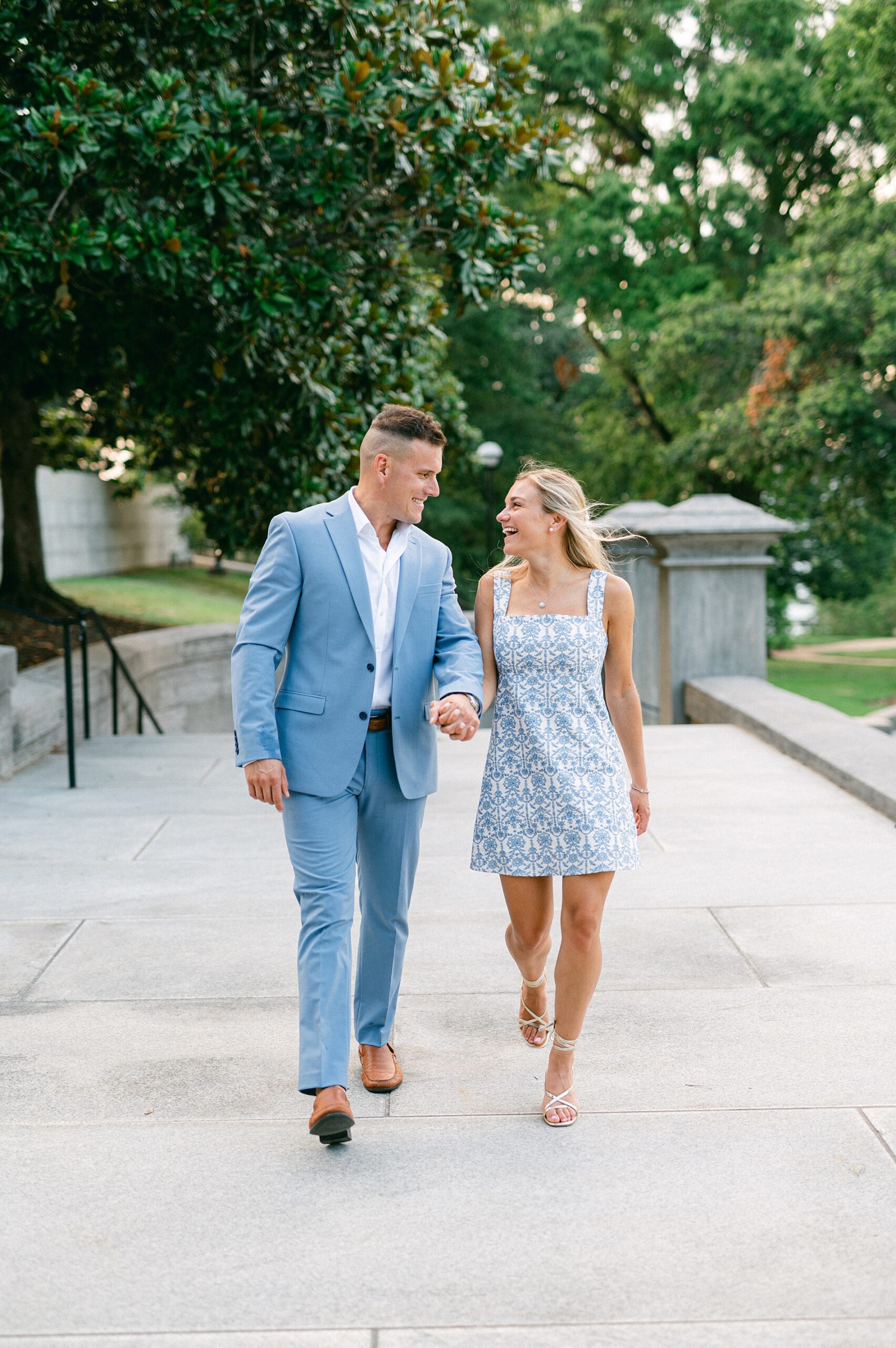 couple walk together near TN Capitol building during summer engagement session 