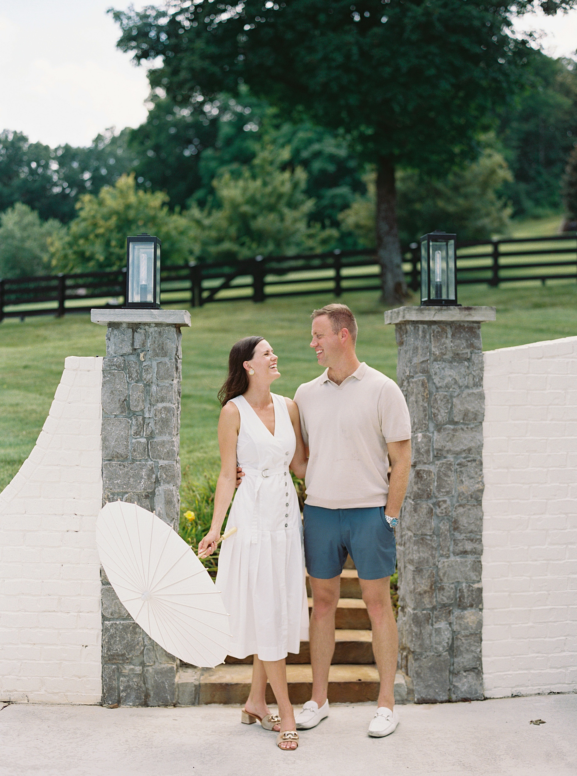 Summer Engagement Outfit Tips woman in lightweight white dress and man in casual outfit 