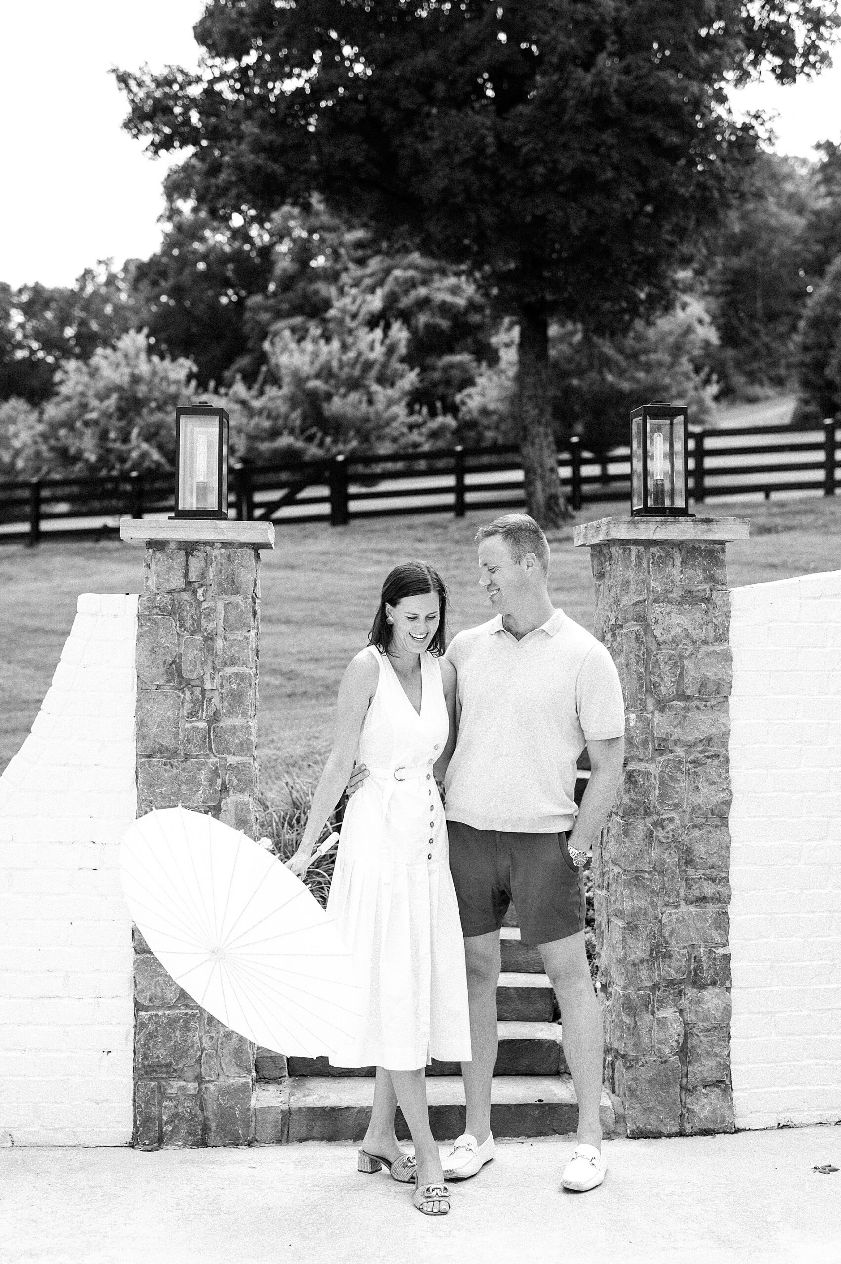woman in white dress holding a parasol with her fiancé