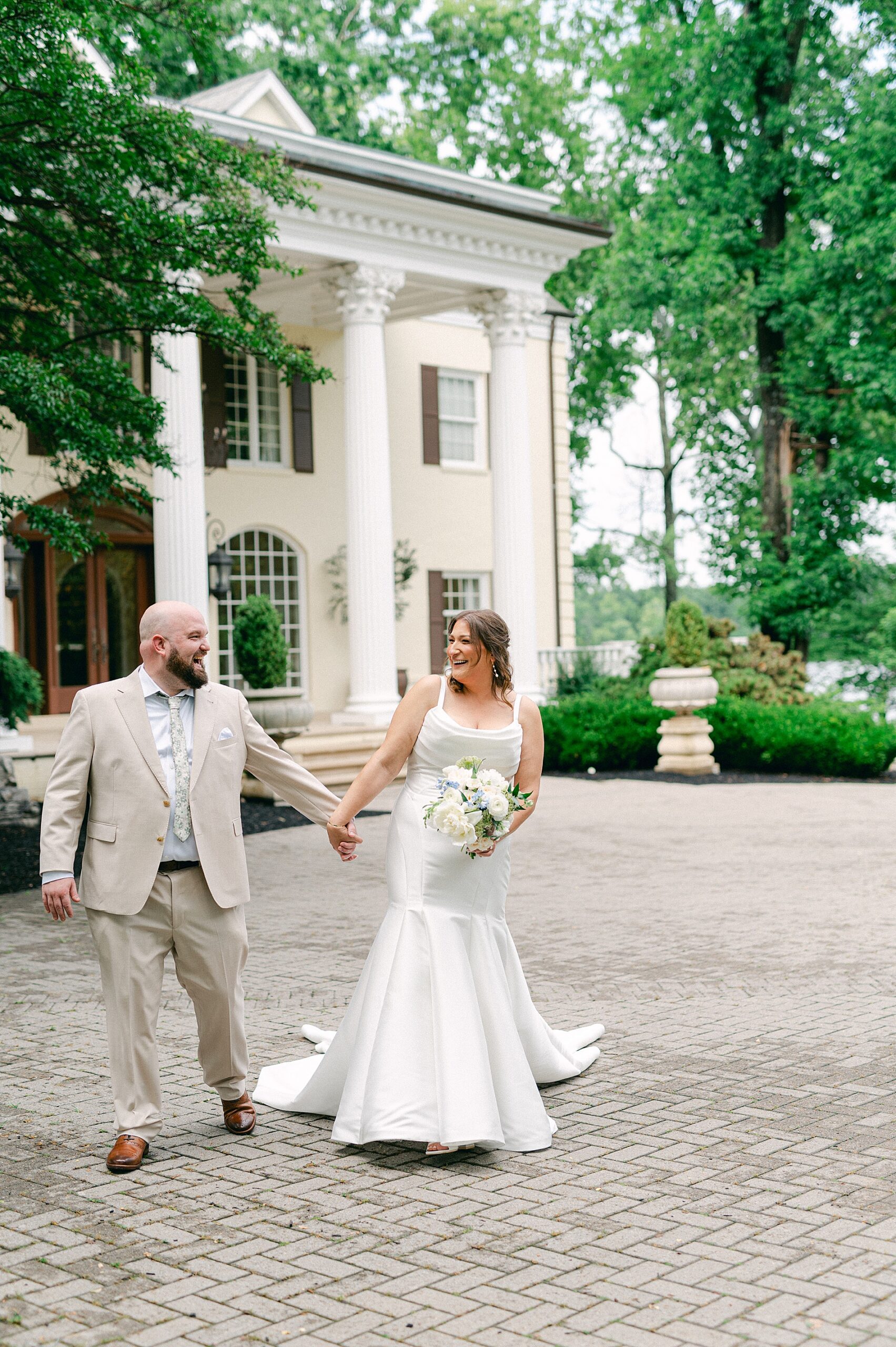bride and groom walk in front of The Estate at Cherokee Dock