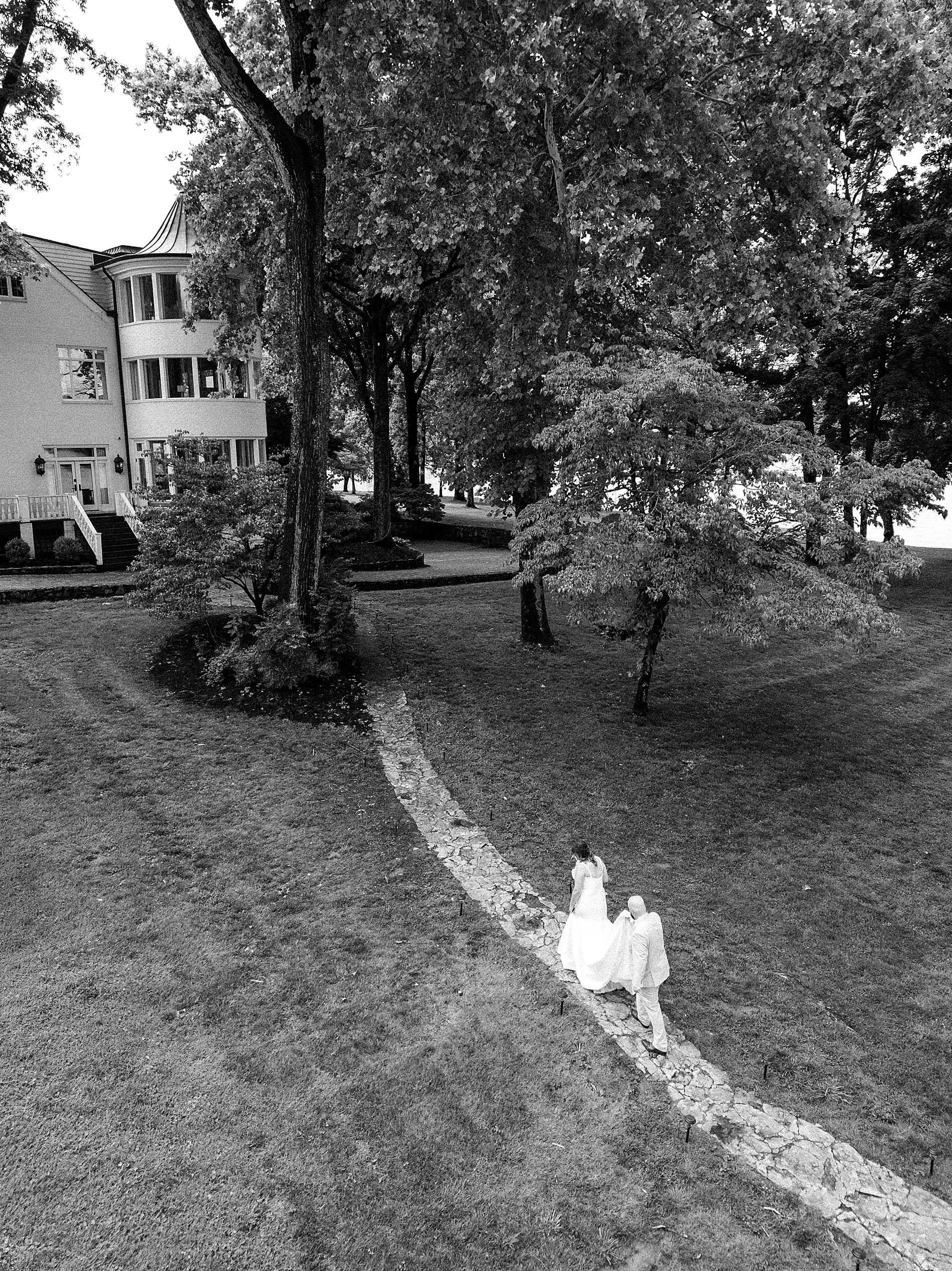 bride and groom walk back towards mansion