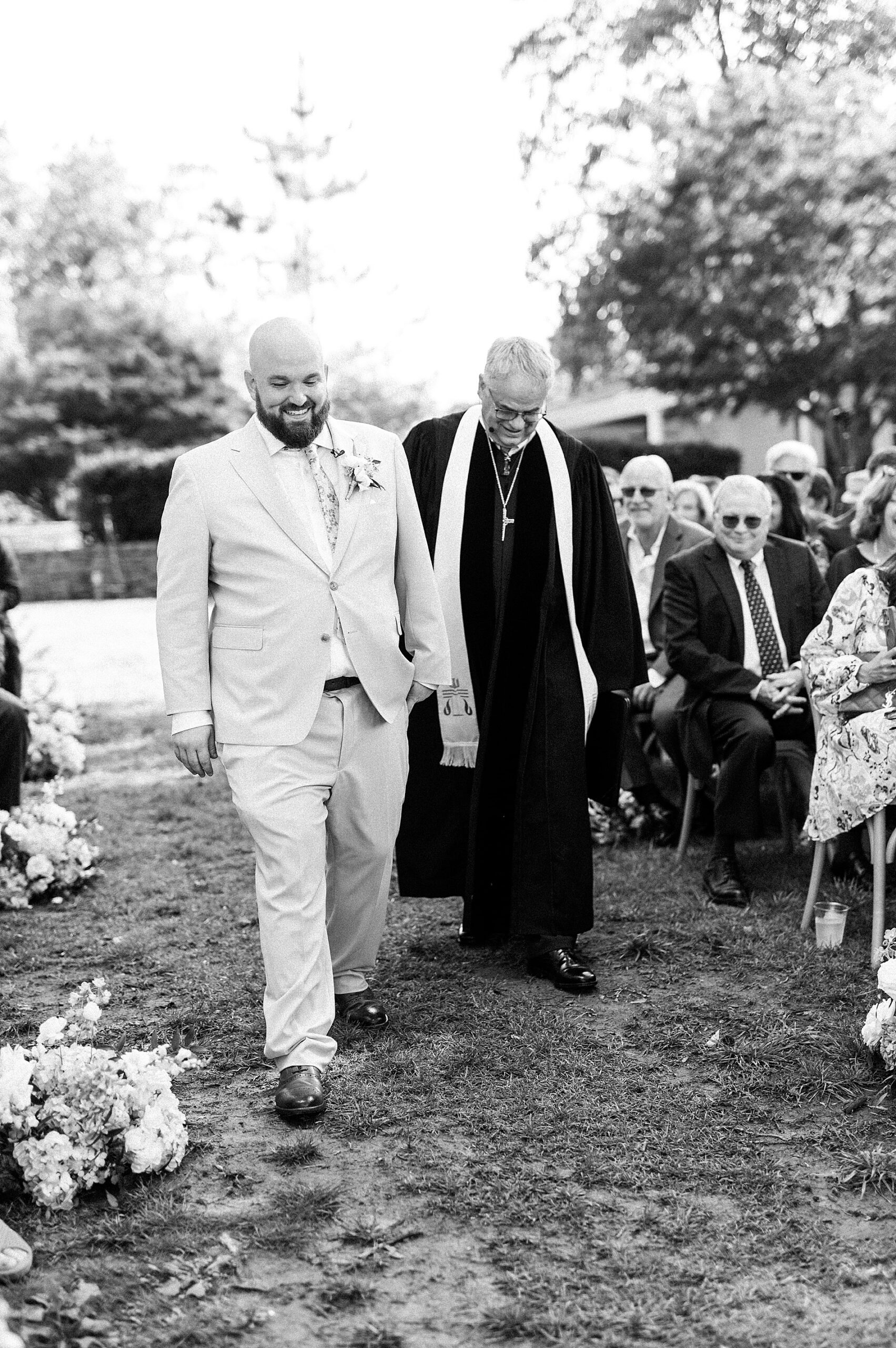 groom and officiant walk down aisle