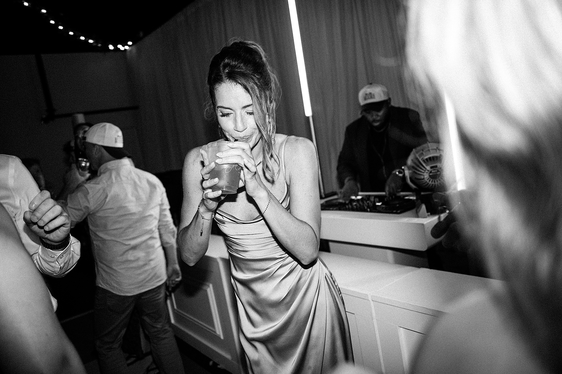 woman on dance floor take a sip of drink