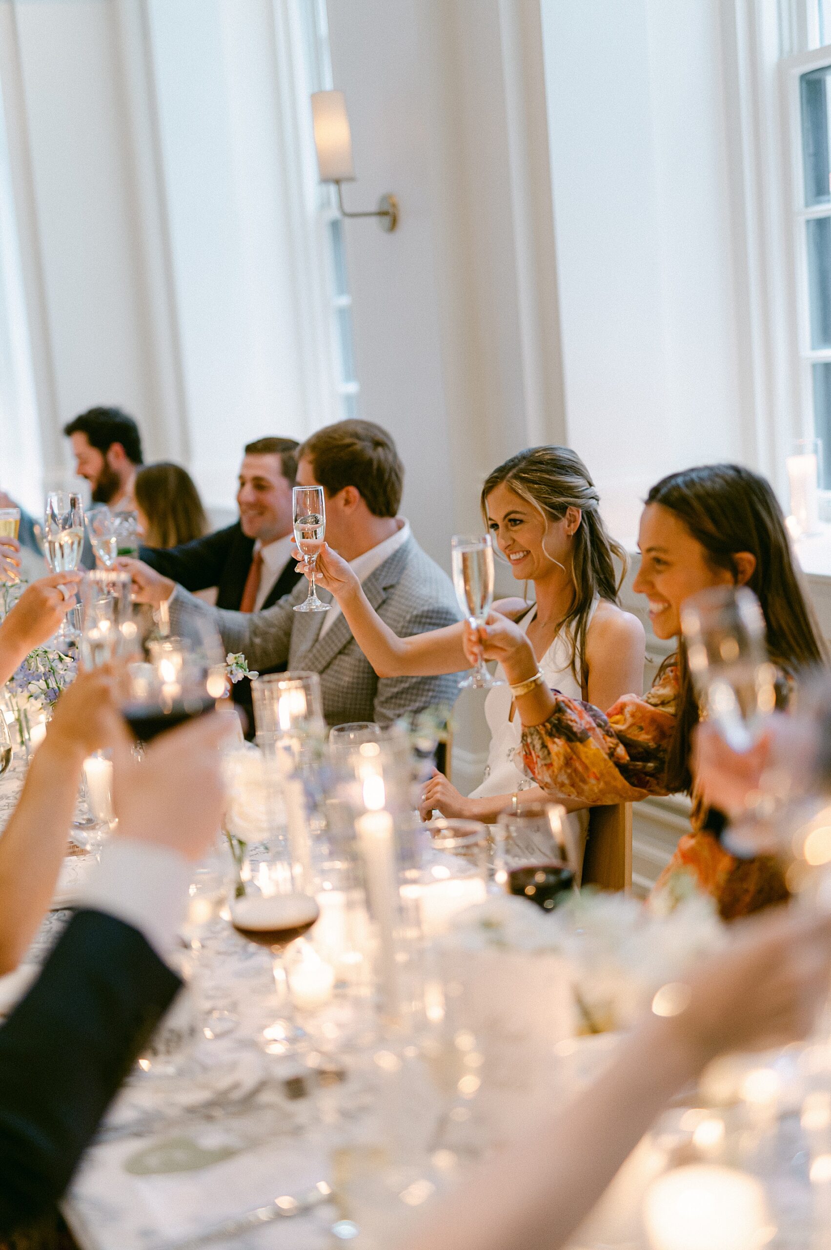 couple and guests raise their glasses a toast