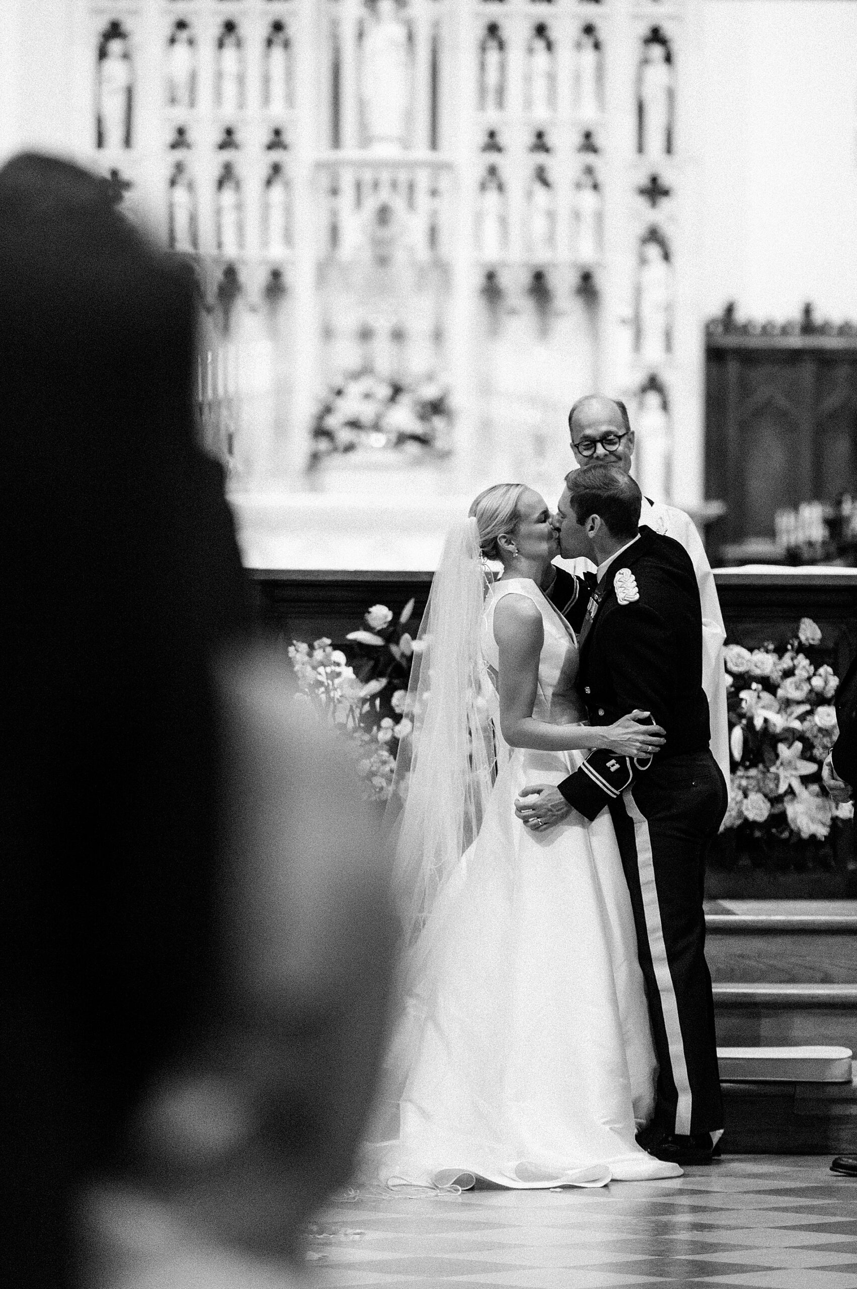 bride and groom kiss at altar