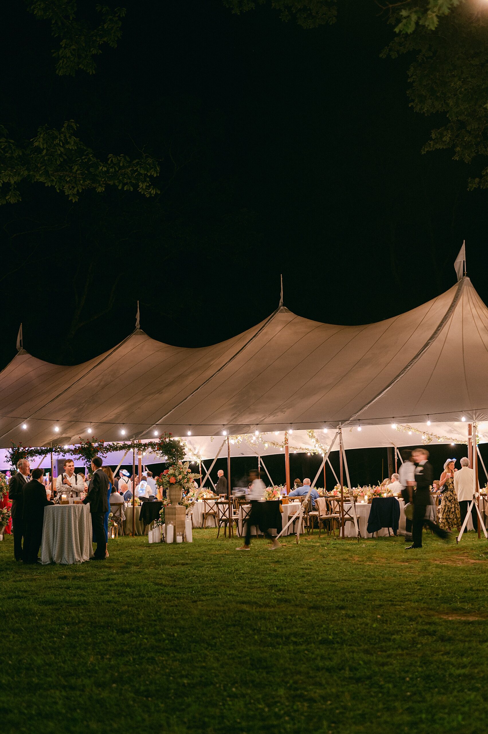 tented summer wedding reception at night lit up
